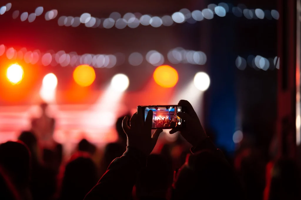 Spectator care filmează un concert, imagine pentru articolul despre oferte de artiști